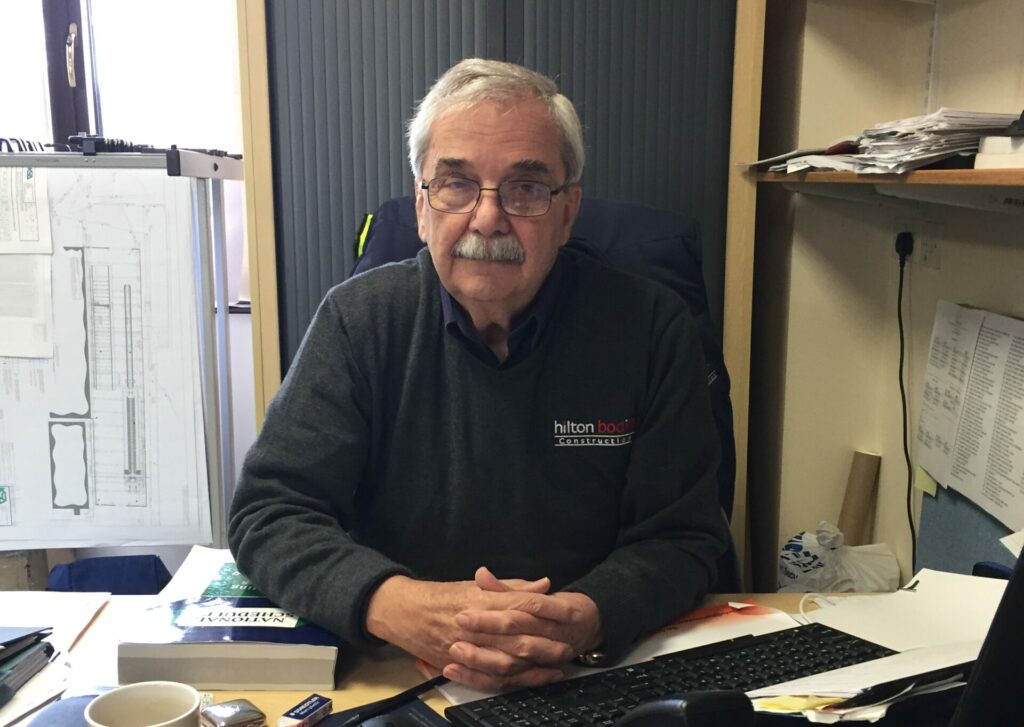 Man with glasses sitting behind his desk