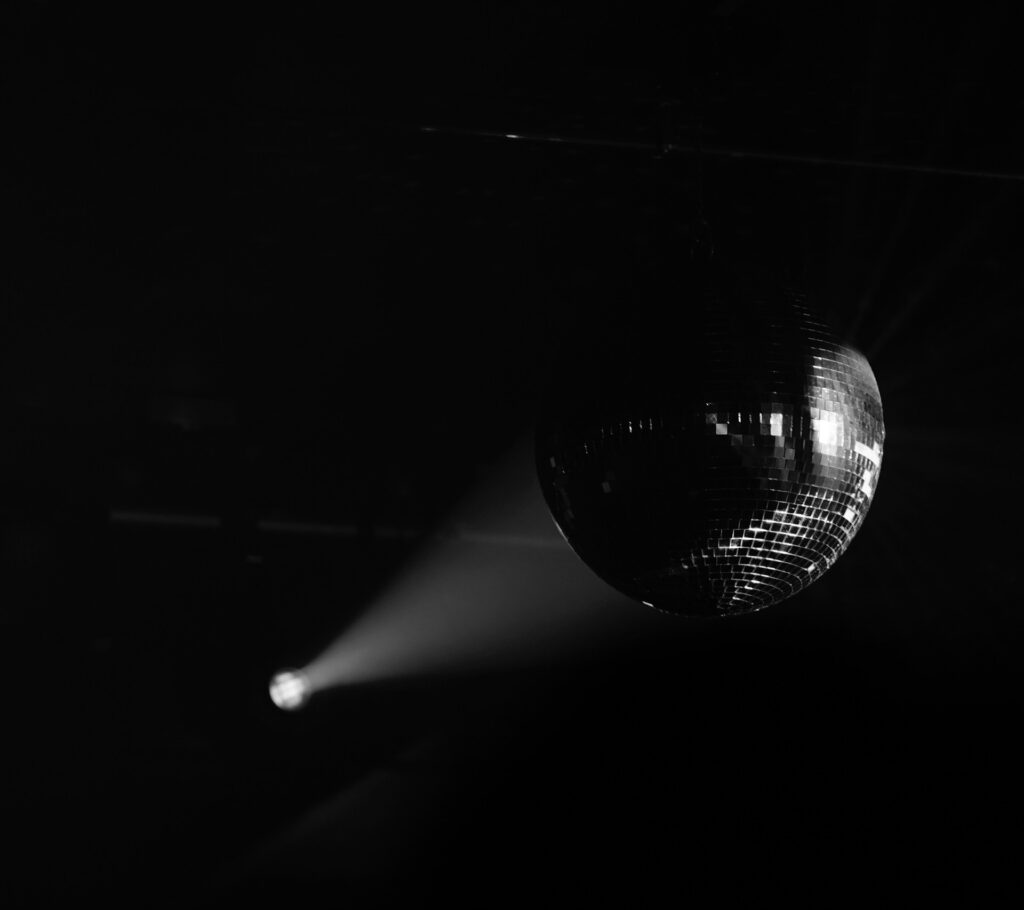 Black and white photo of a spotlight shining on a disco ball.